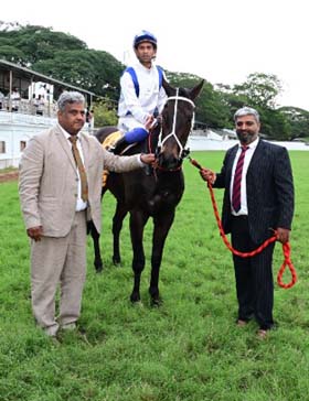 Refined Aggression (Trevor Patel up) winner of the HYDERABAD RACE CLUB MILLION, being led in by trainer Prasanna Kumar on Saturday races at Mysore.